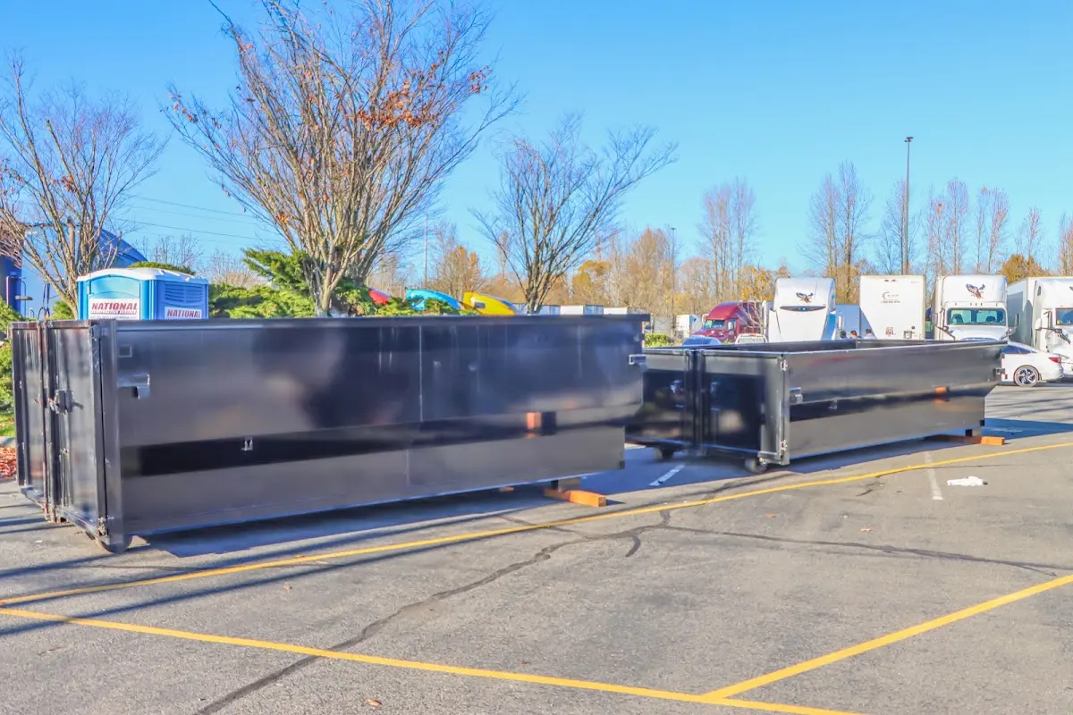 Professional dumpster rental service with roll-off container on residential driveway in Northville